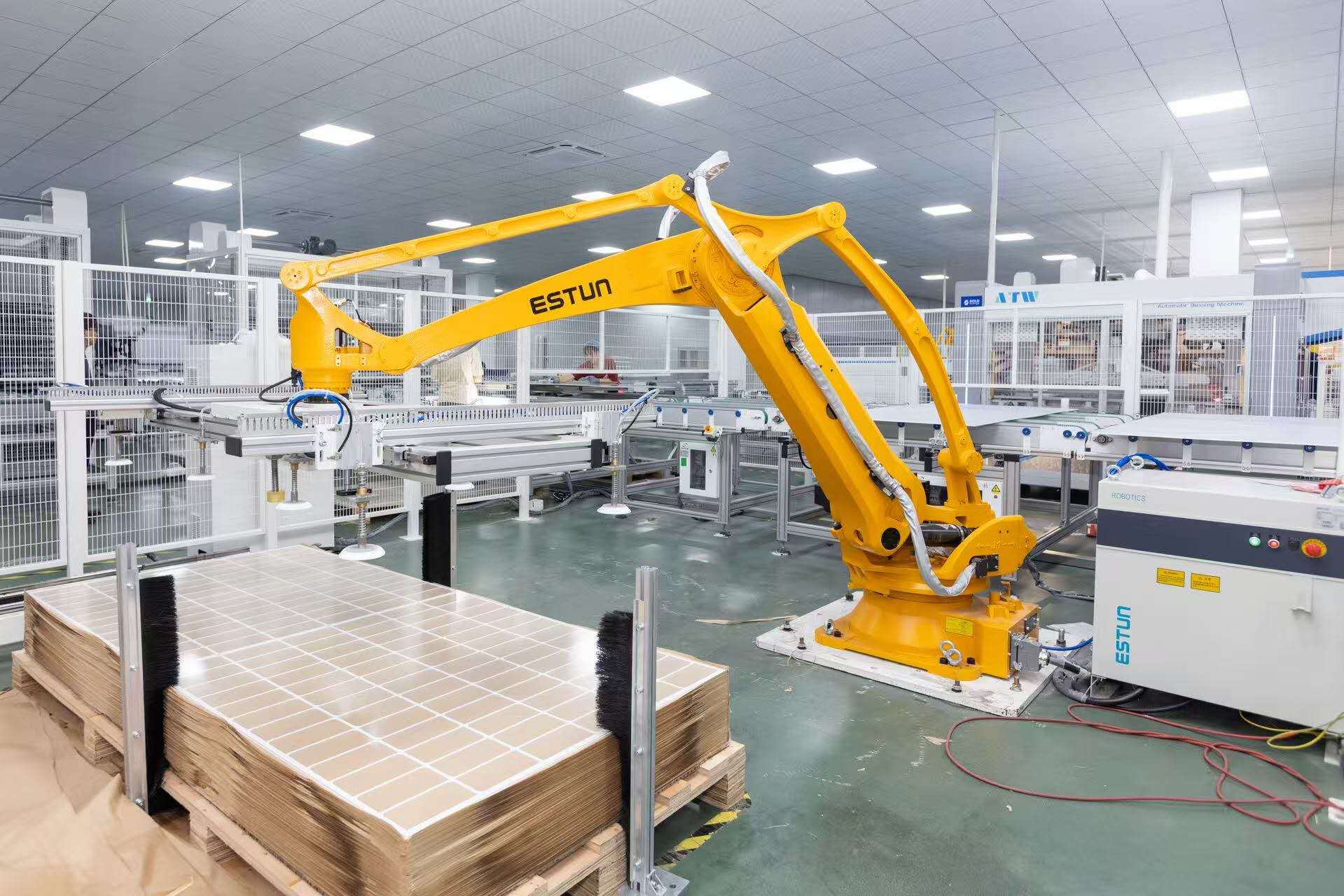 Industrial robotic arm moving solar panels on an automated assembly line